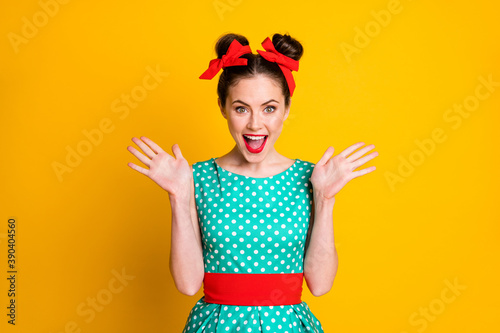 Portrait of pretty glamorous cheerful girl wearing dotted dress good news reaction isolated over vibrant yellow color background