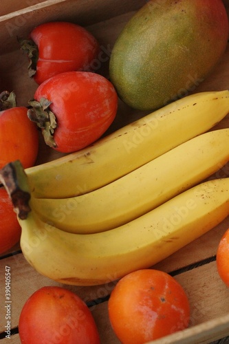 Juicy persimmons bananas and mango close up 