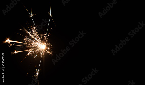 Burning sparkler on a black background with place for text. New year, birthday