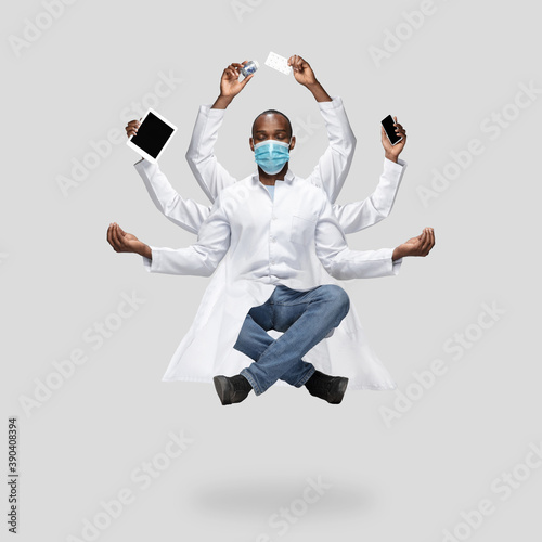 Handsome african doctor, multi-armed man levitating isolated on grey studio background with equipment. Concept of professional occupation, work, job, medicine, healthcare. Multi-task like Shiva.