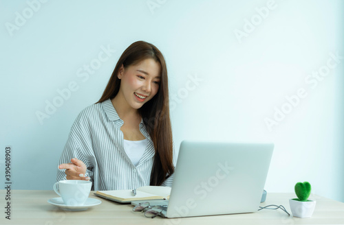 portrait of a beautiful Asian woman Smiling and chatting with friends in online classes, modern study and work at home ideas, online teaching technology.