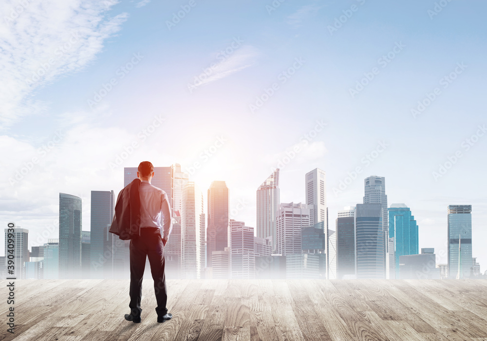 Motivation and inspiration concept with modern cityscape and businessman observing it Motivation and inspiration concept with modern cityscape and businessman observing it