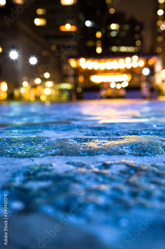 Blurred backdrop image of cobblestone street and lights from New York City.