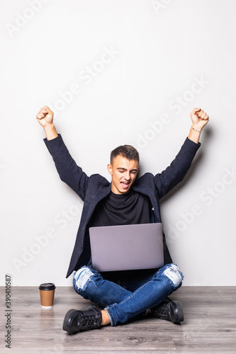 Successful young man holding his laptop on his laptop, isolated on white background