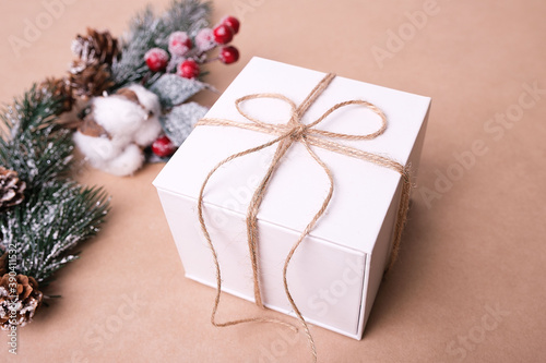 Merry Christmas and Happy Holidays concept. White gift box on kraft paper background.