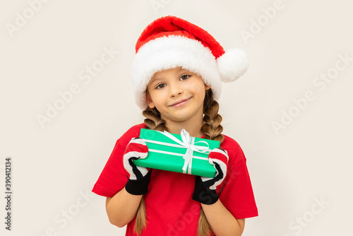 A little girl holds a gift in her hands for Christmas.