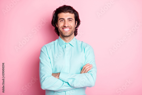 Photo portrait of smiling guy with crossed arms isolated on pastel pink colored background © deagreez