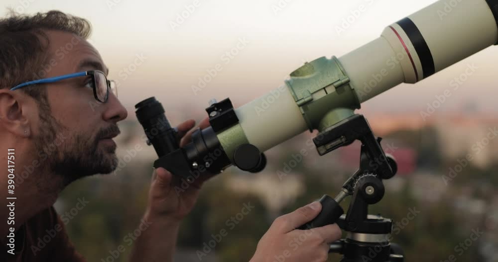 Amateur astronomer looking at the stars with a telescope with blurred city lights in the background.
Amateur astronomer looking at the stars with a telescope with blurred city lights in the background.