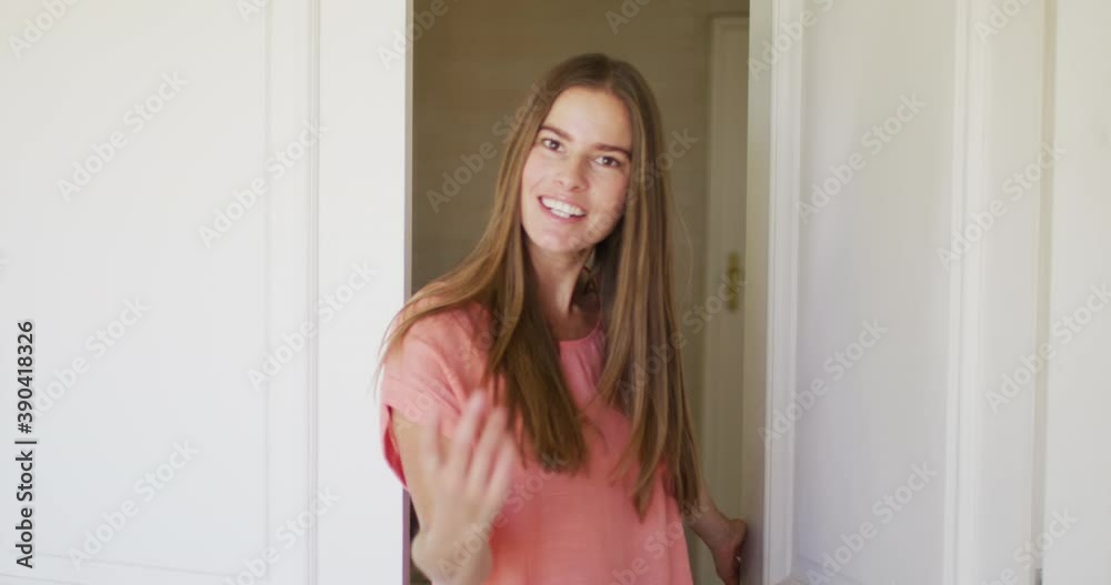 Portrait of caucasian woman opening house front to welcome people in Portrait of caucasian woman opening house front to welcome people in