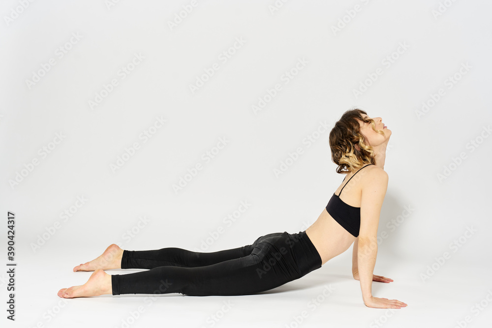 Sportive woman will do the exercise lying on the floor Gymnastics fitness in a bright room