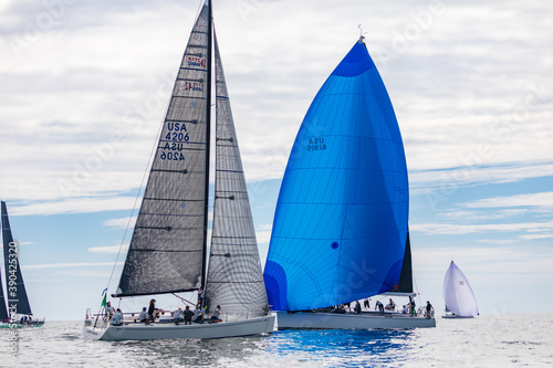 Фотография Yachts racing in the ocean with blue spinnaker and black sails