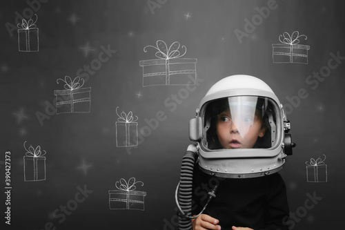 a child in an astronaut's helmet dreams of Christmas and presents © vovan