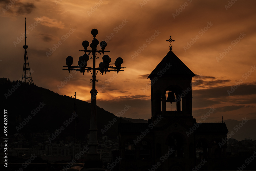 dark silhouette of the church against the background of an orange sunset sky