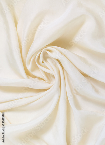 Delicate tender creme crumpled silk background, selective focus