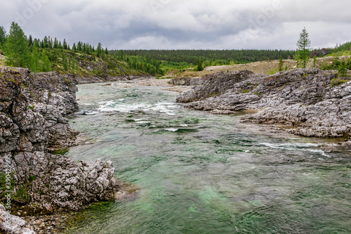 northern river flowing among the rocks in a forest area