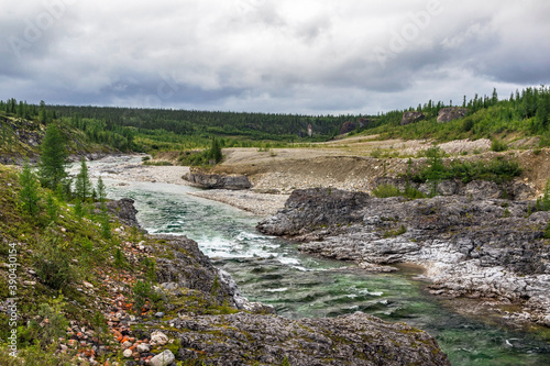 northern river flowing among the rocks in a forest area