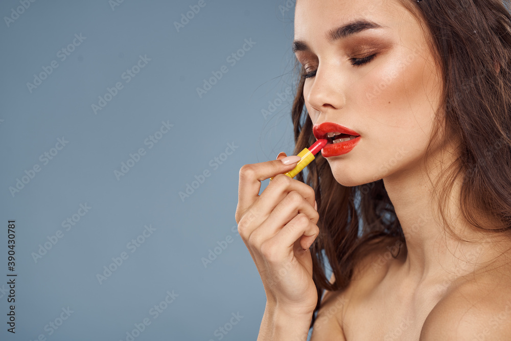 Woman with lipstick on a gray background brunette makeup with eye shadow on the eyelids Woman with lipstick on a gray background brunette makeup with eye shadow on the eyelids