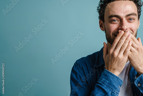 Cheerful handsome guy posing and covering his mouth