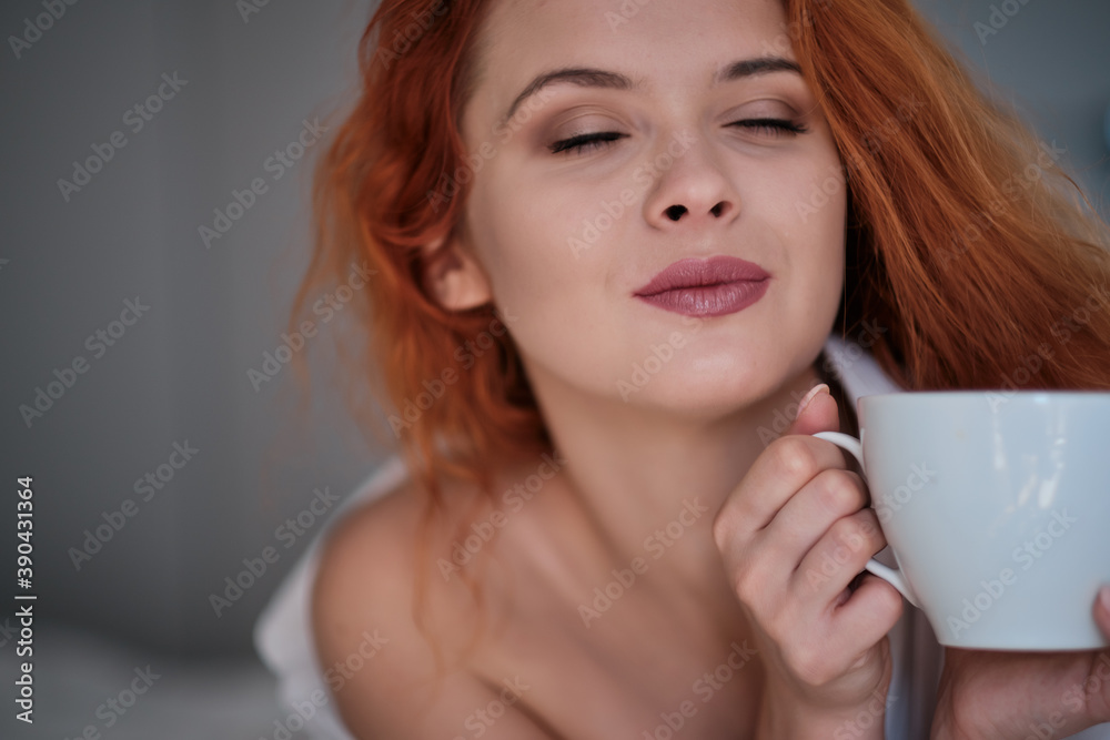 Beautiful young woman with cup of coffee at home