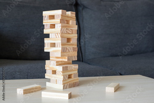 Wooden block tower on the table with dark grey couch in the bakground photo