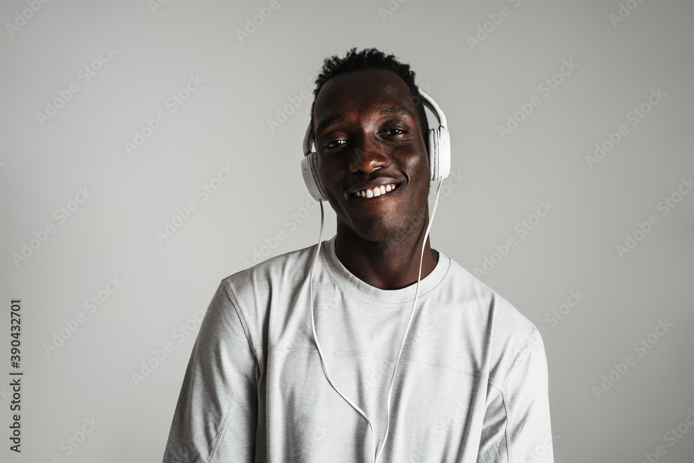 Obraz premium Happy african american guy listening music with headphones and smiling