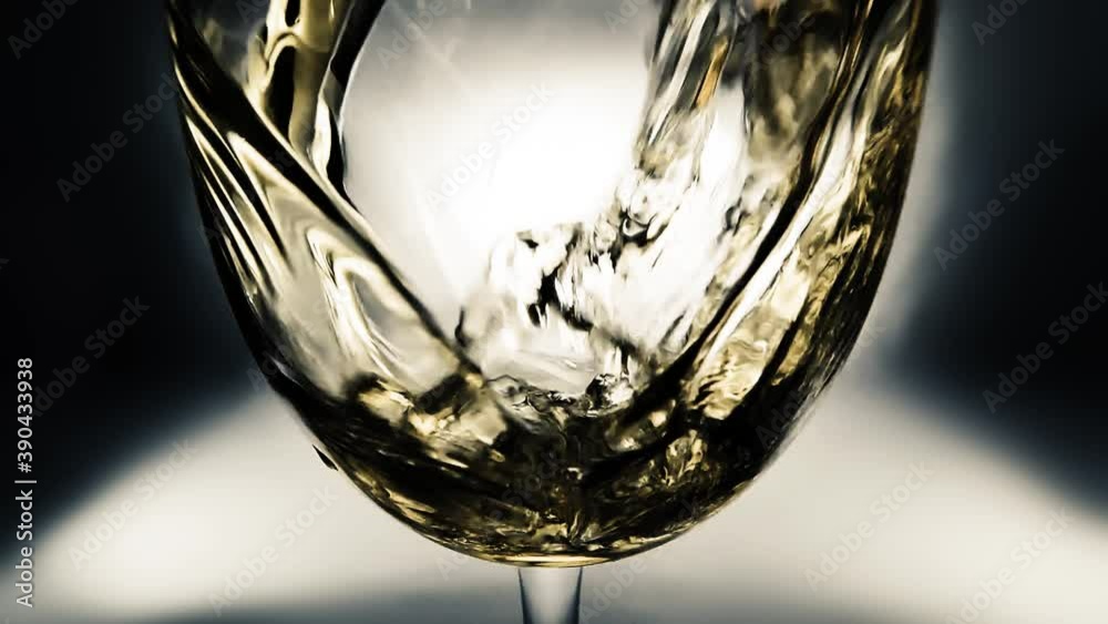 Creative macro slow motion video of white wine pouring into a glass. Glass with pouring white wine close-up. Old retro grunge vintage style.