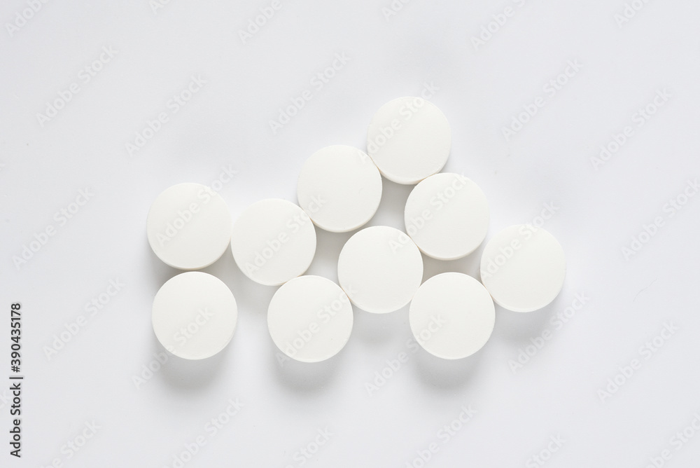 White medicine pills on white background