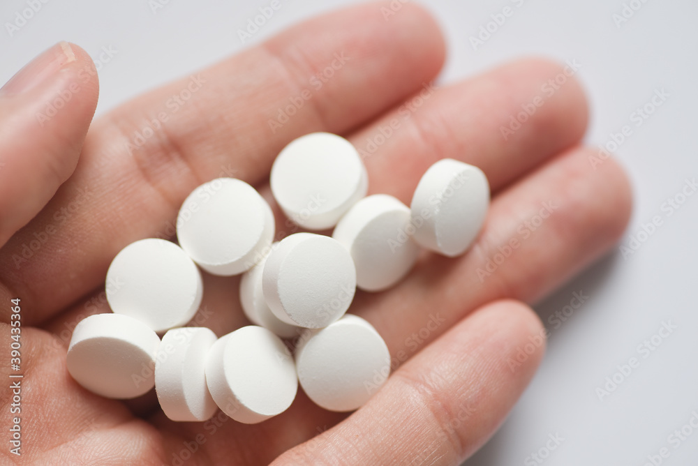 Close up photo of Round white pills on hand Close up photo of Round white pills on hand