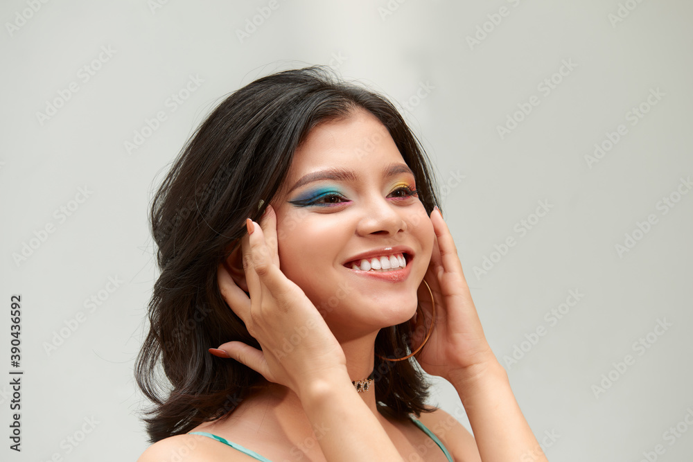 Make-up and cosmetics. Portrait of a beautiful smiling girl with bright colorful make-up on a white background Make-up and cosmetics. Portrait of a beautiful smiling girl with bright colorful make-up on a white background