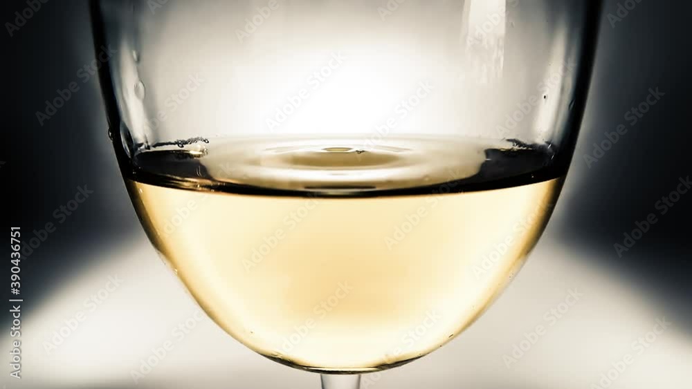 Creative macro slow motion video of white wine in a glass and a falling drops of wine. A glass with a slowly falling drops of wine close-up. Old retro grunge vintage style soft faded. Creative macro slow motion video of white wine in a glass and a falling drops of wine. A glass with a slowly falling drops of wine close-up. Old retro grunge vintage style soft faded.