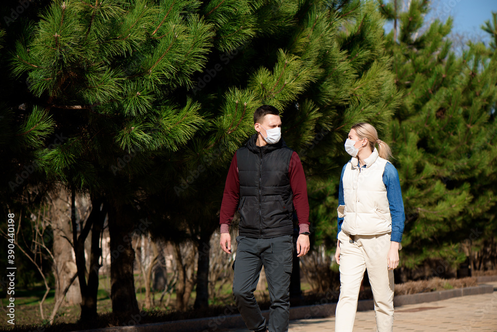 Fototapeta premium Young European man and woman in protective disposable medical mask walking outdoors afraid of dangerous NCoV 2019 influenza coronavirus mutated and spreading in China