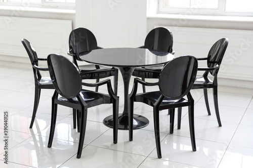 black chairs around the table are in white room