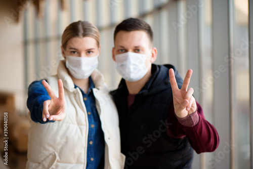 Family in face mask in shopping mall or airport. Couple wear facemask during coronavirus and flu outbreak. Virus and illness protection in public crowded place.