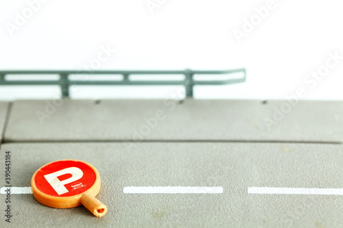 Miniature traffic signage parking sign put on the road plate model scene represent road safety concept idea.