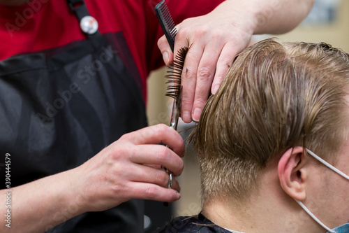 Male haircut process close up during pandemic. People wear face masks