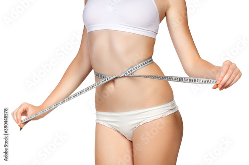 Woman measuring her waist with a tape meter, isolated on white background