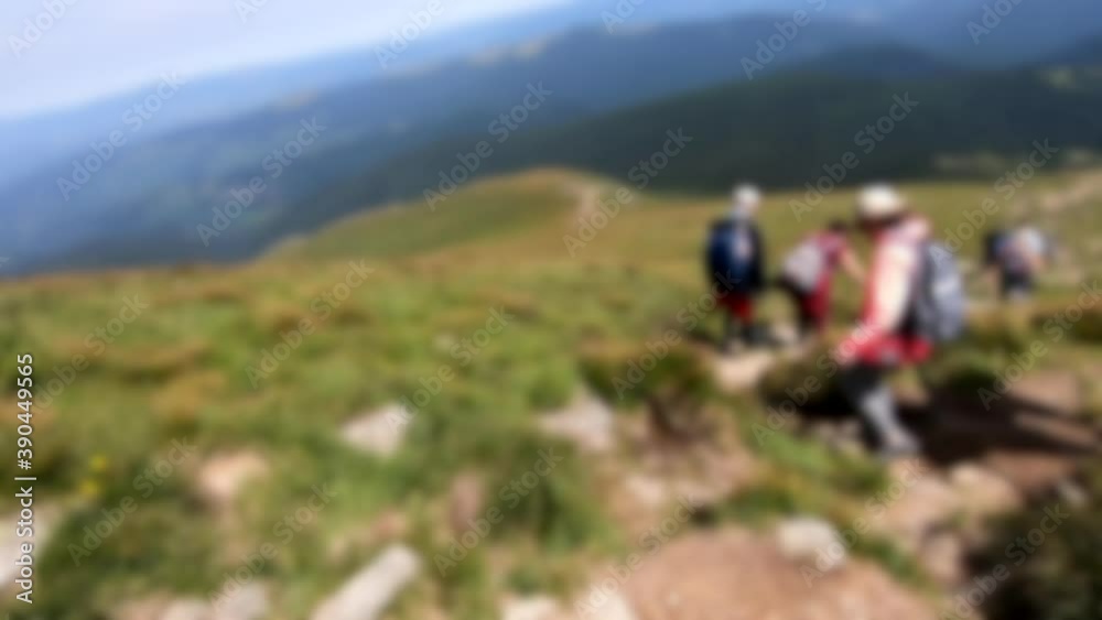 Blurred background. Person go down mountain. People walk on dirt mountain trail