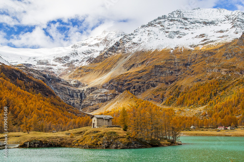 Little stone house on the islet of the Palu Lake below Piz Palu glacier in Swiss Alps in autumn day, Canton of Grisons, Switzerland