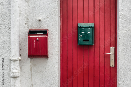Buzones de colores sobre puerta roja © Oscar