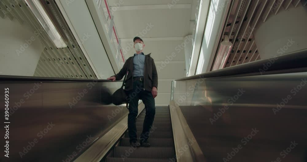 Man in face mask standing on escalator Man in face mask standing on escalator