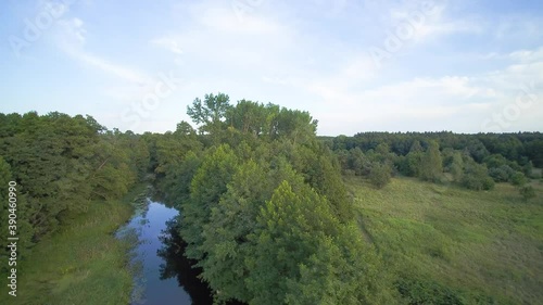 Low flyover over a small wild river on a summer day, river Grabia, Poland. photo