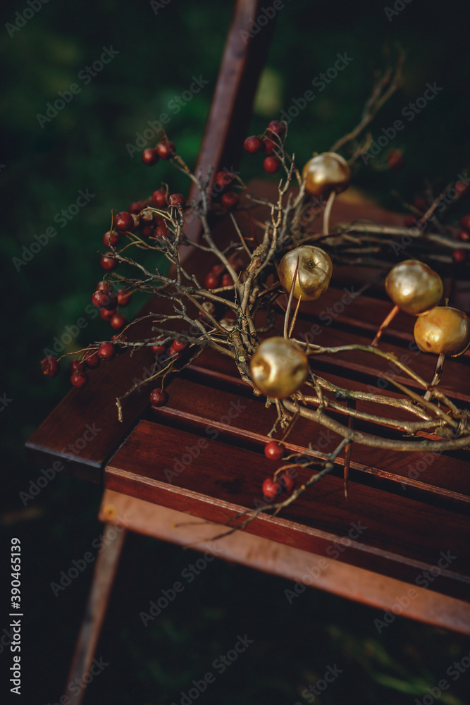 autumn wreath with thorns and apples on a wooden chair