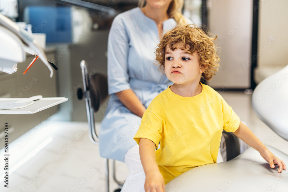 Cute young boy visiting dentist, having his teeth checked by female dentist in dental office. Cute young boy visiting dentist, having his teeth checked by female dentist in dental office.