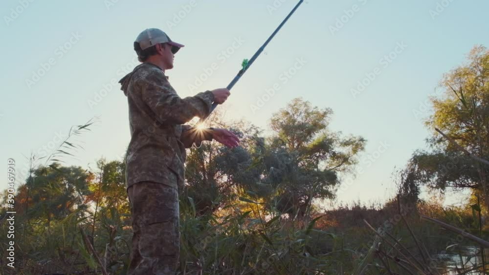 Fisherman on the river. Amateur angler fishing on the river from its coast Fisherman on the river. Amateur angler fishing on the river from its coast