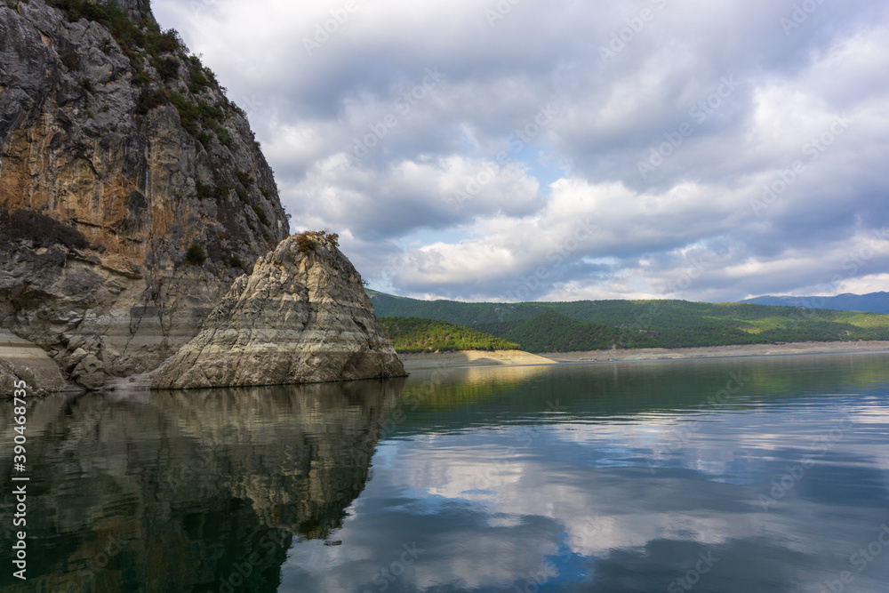 
Reflection of rocks in water on a cloudy day