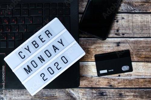cyber monday word written on lightbox on brown wooden background. Flat lay, top view.