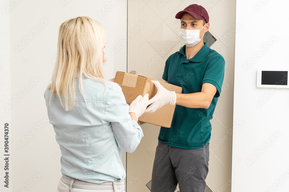 Obraz premium Woman and courier during order transfer. Woman accepting delivery from deliveryman. Cropped image of delivery service worker giving parcel to client.