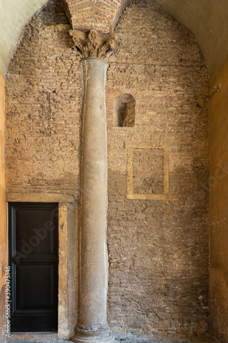 Antique vault, door and pillar, aging and brick walls with yellow, burnt umber, saffron, sand paint peeling off coatings outdoors on a shabby background. in Italy  open teal water pipe Vintage