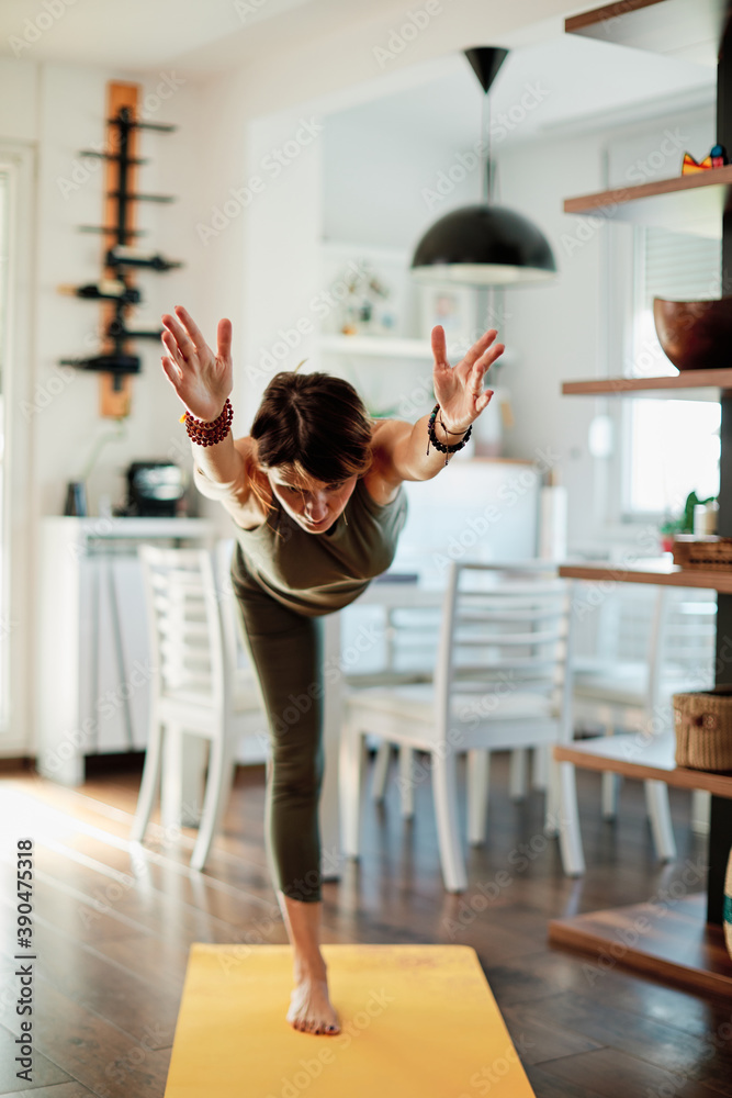 Fototapeta premium Middle aged yogi woman doing yoga at home.