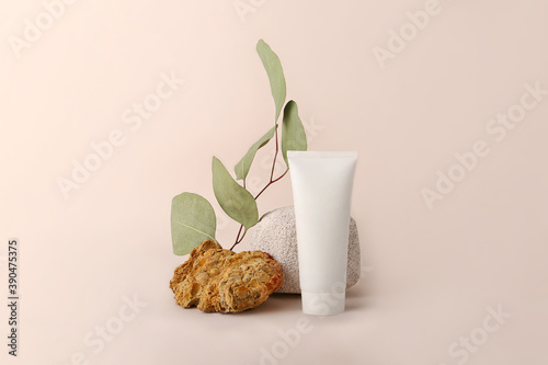 Composition from the natural materials and cosmetics tube near it.Copy space for text or design.Can be used as advertising banner.Pastel colors.Mockup concept.